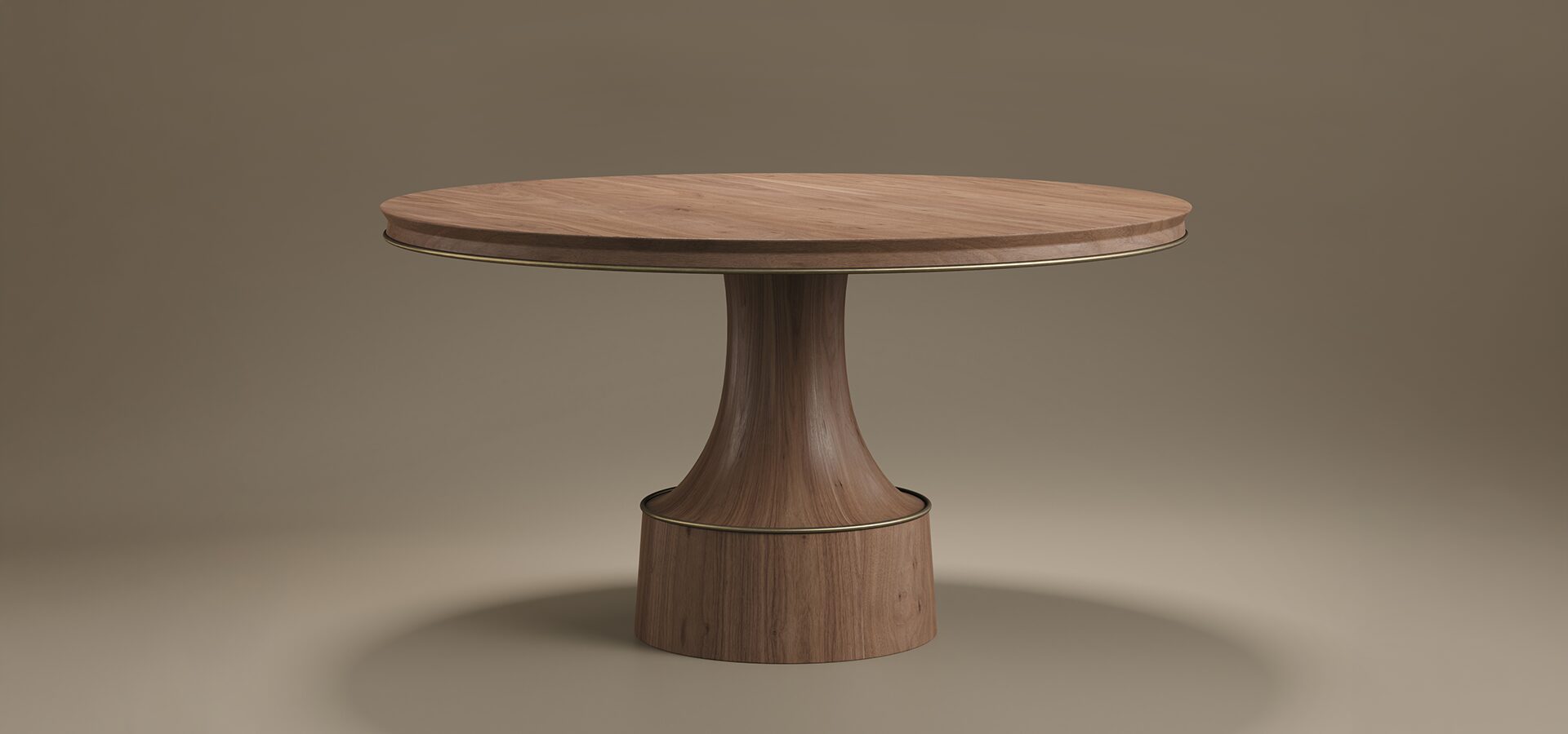 A round Buck Dining Table by Porus Studio featuring a rich walnut wood top and a sculptural pedestal base, accented with aged brushed brass details, set against a neutral studio background.