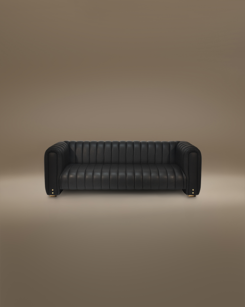 A luxury Inglewood Sofa featuring a sophisticated design with continuous vertical tufting across the seat, backrest, and rounded armrests. Upholstered in premium black leather, the sofa is accented by small, polished brass stud details on the front of the arms and rests on subtle brass-finished cylindrical feet. Set against a minimalist, warm taupe studio background.