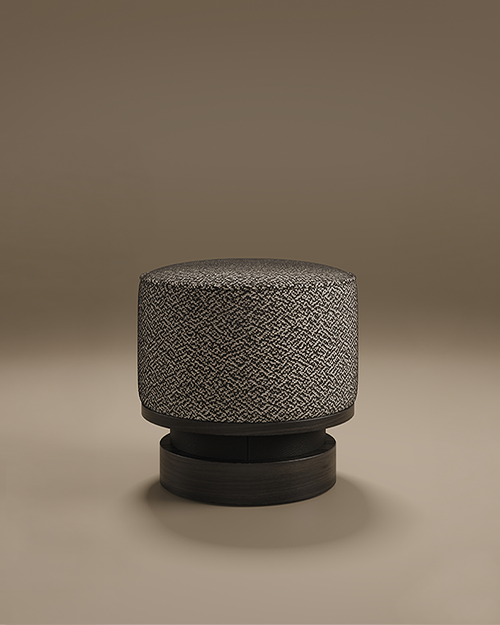 Minimalist studio shot of the Wyo Stool by Porus Studio set against a warm, neutral taupe background. The stool features a thick, cylindrical cushioned seat upholstered in a high-contrast black and white textured fabric. It is supported by a sculptural, tiered pedestal base made of dark, matte-finished wood, creating a sophisticated and grounded silhouette.