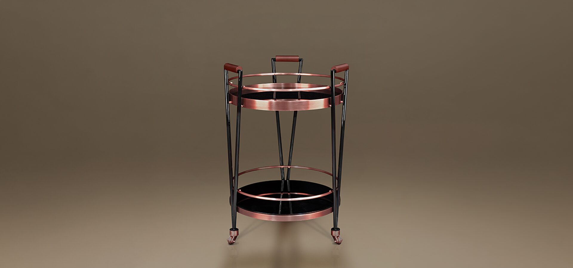 A stylish, high-quality image of the Crossroads Bar Cart by Porus Studio against a neutral, warm-toned studio background. The bar cart features a sophisticated contemporary design with a circular dual-tier structure. Its frame is composed of sleek black lacquered wood legs that taper downwards, accented by brushed copper-finished metal rings and details. The two shelves consist of deep black glass or mirrored surfaces, providing a glossy contrast to the metallic trim. Three vertical supports extend upwards to form ergonomic handles wrapped in rich brown leather. The piece is mounted on three small, discreet wheels for mobility, blending mid-century modern inspiration with luxury craftsmanship.