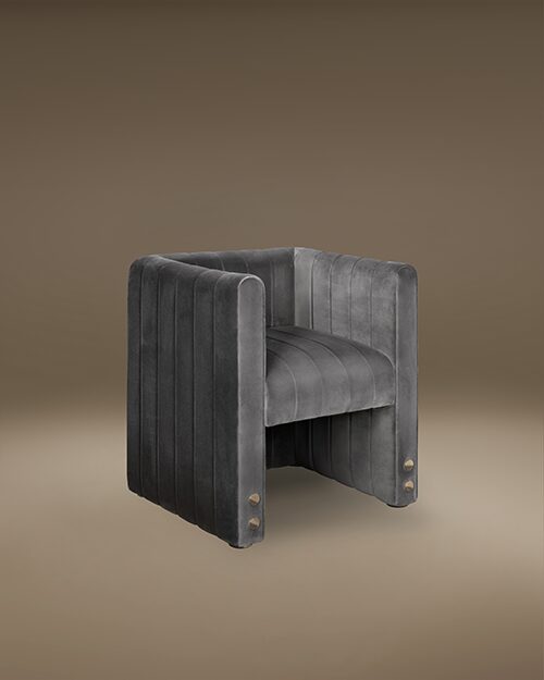 Modern Inglewood Dining Chair by Porus Studio, featuring a fully upholstered cubic design in grey velvet with vertical channel tufting and decorative gold stud details at the base.