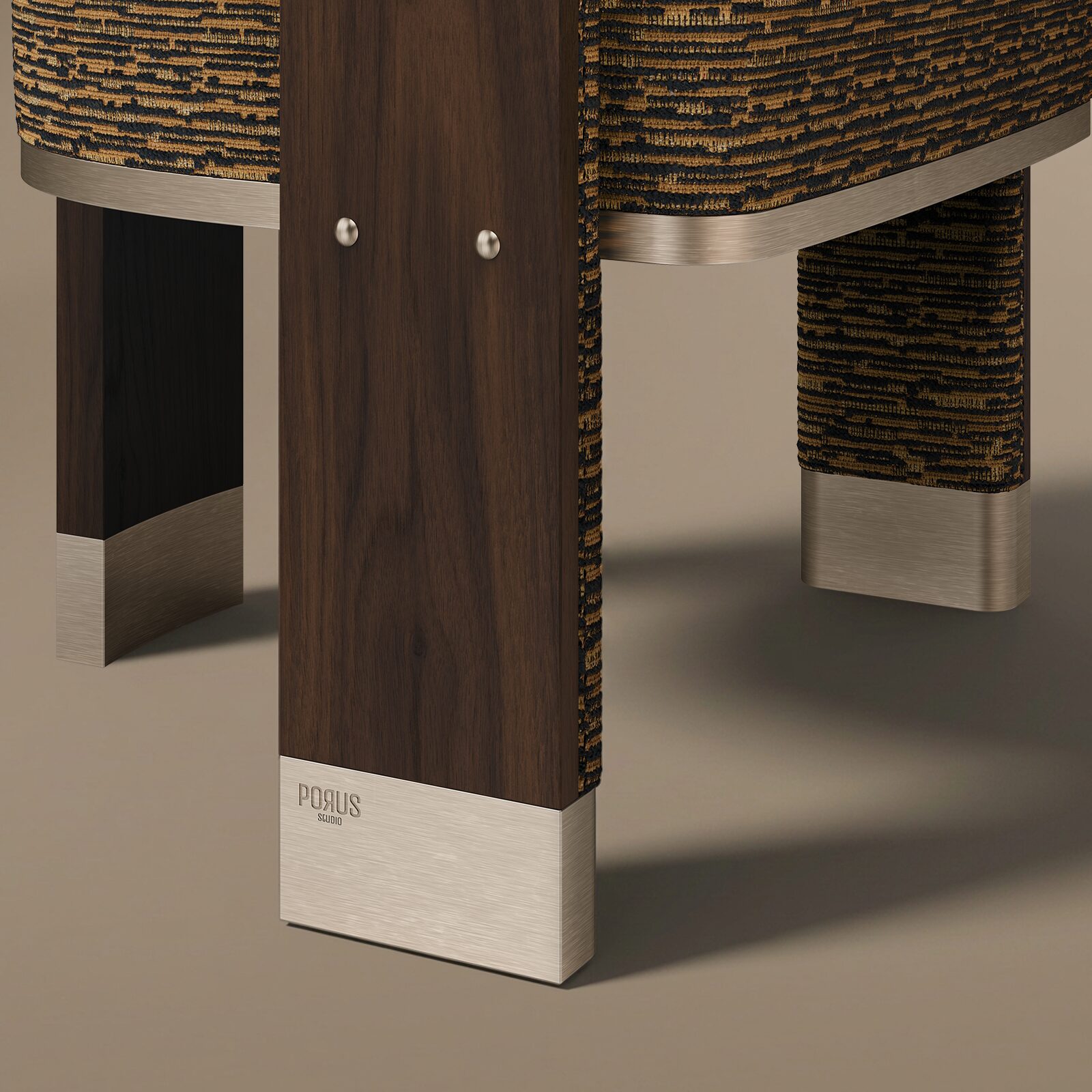 Brooklyn Dining Chair Extreme close-up detail of the front leg of the Porus Studio Brooklyn Dining Chair, highlighting the smooth, dark walnut wood grain, the precise attachment points, the textured merged weave jacquard fabric, and the engraved brand logo on the brushed champagne stainless steel foot. The leg rests on a warm-toned neutral surface.