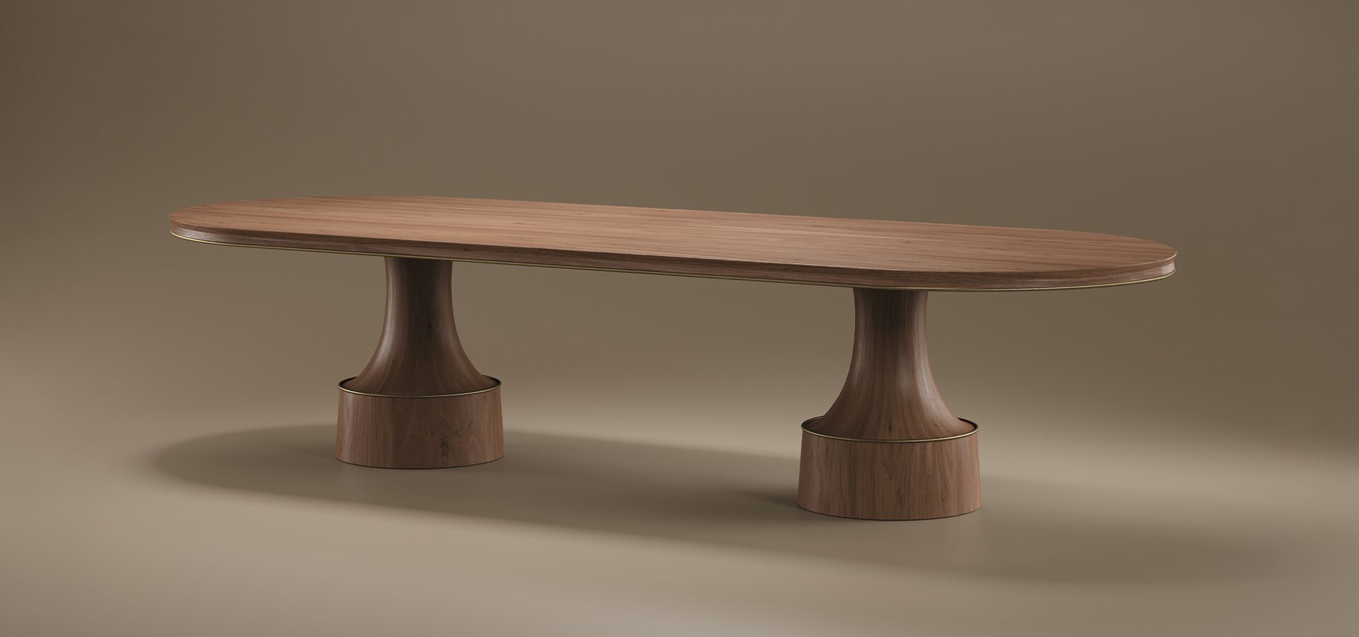 A large Buck Oval Dining Table by Porus Studio crafted from walnut wood, featuring an expansive oval top supported by two signature sculptural pedestal legs with aged brushed brass frames.