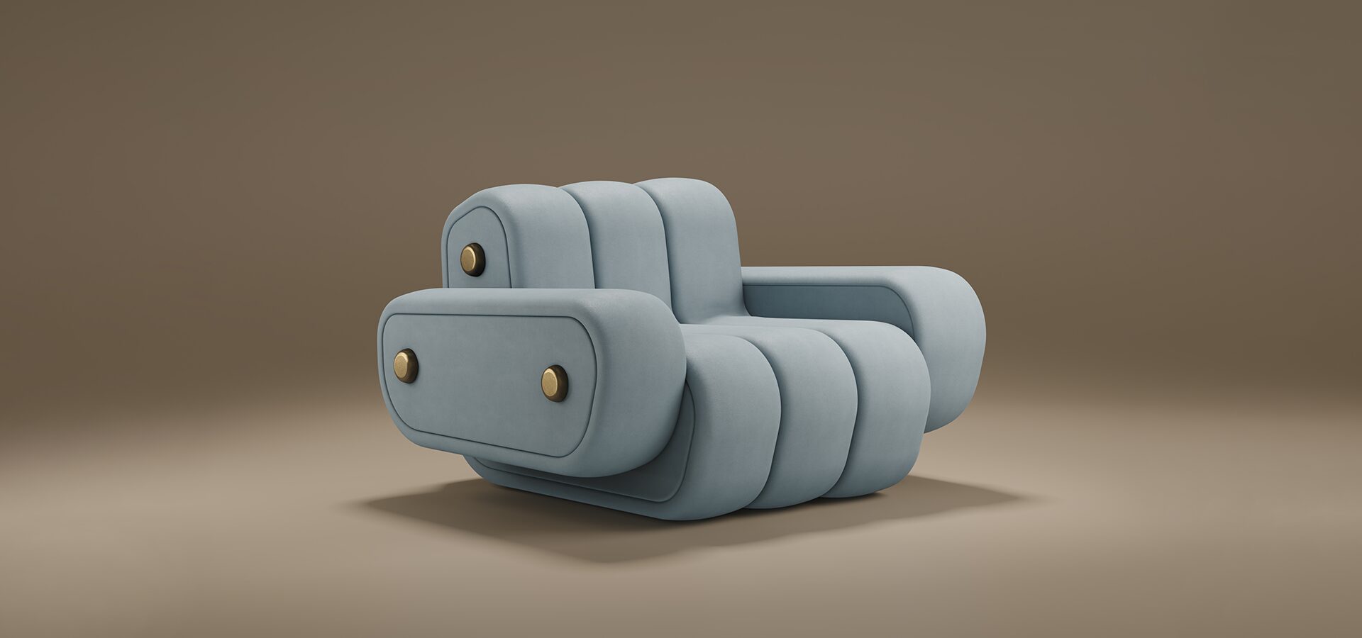 A professional studio shot of the Dakota Armchair by Porus Studio, presented against a soft, neutral brown background. The armchair features a bold, modular aesthetic with a low-profile silhouette. It is fully upholstered in a smooth, pale blue-grey velvet, characterized by thick, vertical channeled tufting that creates a rounded, "puffy" appearance. The wide, blocky armrests and the backrest are embellished with distinctive brushed brass circular studs, adding a touch of industrial luxury to the soft design. The chair sits on a recessed base, giving it a heavy, grounded, yet contemporary feel.