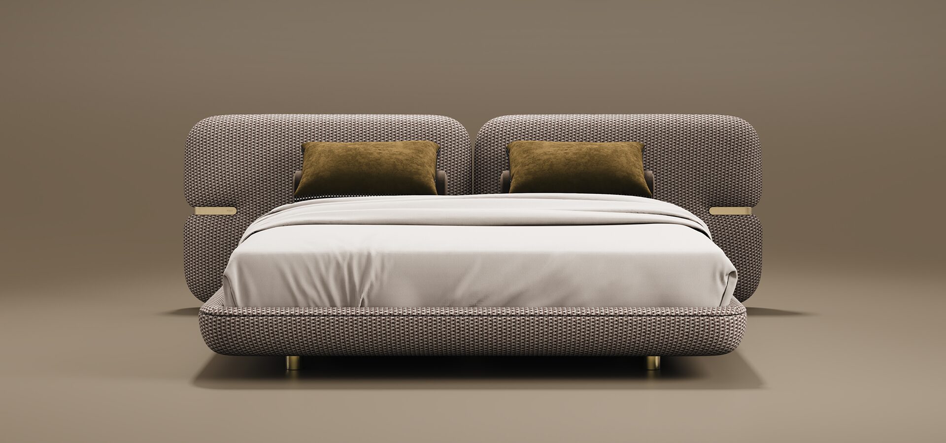 Newark Bed A contemporary Newark Bed featuring a wide headboard and frame upholstered in a textured, woven fabric. The headboard is split into two large rounded panels, each accented with a polished brass inset detail on the outer sides. Two mustard-yellow velvet cushions lean against the headboard, contrasting with the neutral white bedding. The bed is supported by small, cylindrical brass feet and set against a warm taupe background.