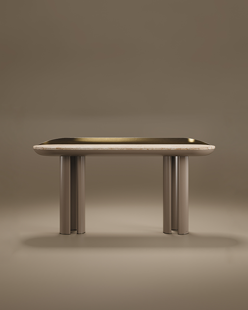 A luxury Beverly Console by Porus Studio featuring a rounded stone top. The back of the surface is accented by a curved, elevated rail in brushed brass. The console is supported by two thick, fluted pedestal legs finished in lacquer, matching the sculpted underside of the tabletop. The design is elegant and mid-century modern inspired, presented against a neutral taupe studio background.
