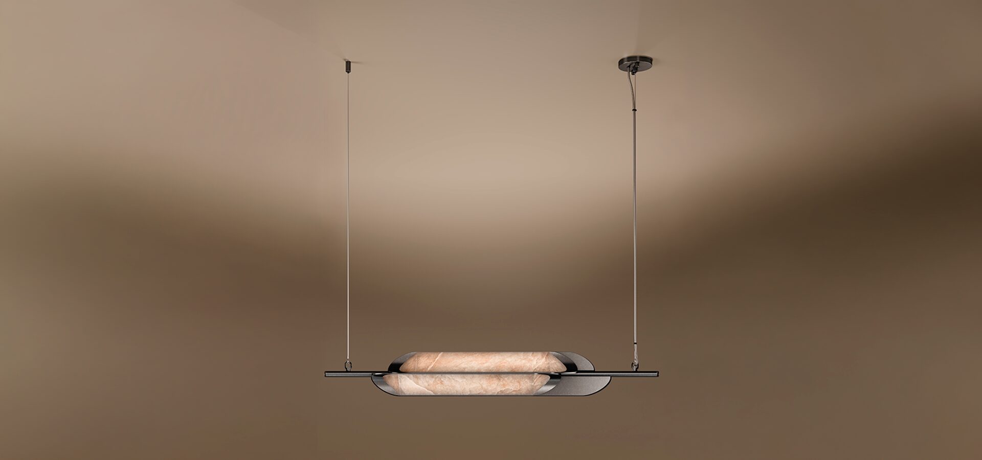 Glacier II Pendant Lamp A horizontal Glacier II pendant lamp by Porus Studio, featuring a sleek, minimalist design. A luminous, capsule-shaped center made of textured alabaster is cradled by dark, curved metallic plates. The fixture is suspended from the ceiling by two thin vertical cables against a warm, neutral gradient background.