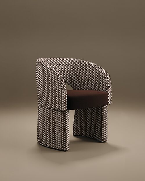 The Montana Dining Chair by Porus Studio, featuring a curved barrel back and architectural base in a black and white patterned weave with a dark brown velvet seat.