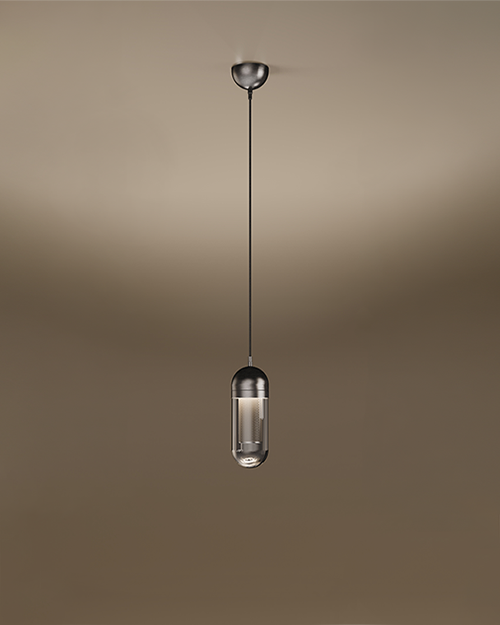 The Denver I pendant lamp by Porus Studio, featuring a sophisticated capsule-shaped design. The fixture consists of a dark metallic top dome and a transparent glass bottom, revealing a glowing internal mesh cylinder. It hangs from a single black cord with a matching metallic ceiling rose, set against a soft, warm-toned studio background.