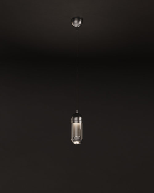 A professional studio photograph of the Denver I Pendant Lamp by Porus Studio, shown hanging and illuminated against a dark background. The light glows from within a lacquered perforated stainless steel cylindrical core, which is encased in a rounded clear glass capsule. The internal light source creates a sophisticated diffused glow as it passes through the metal perforations, casting a textured pattern and highlighting the sleek stainless steel upper structure. The light emits a focused downward beam while creating a soft, ambient brilliance through the glass body.