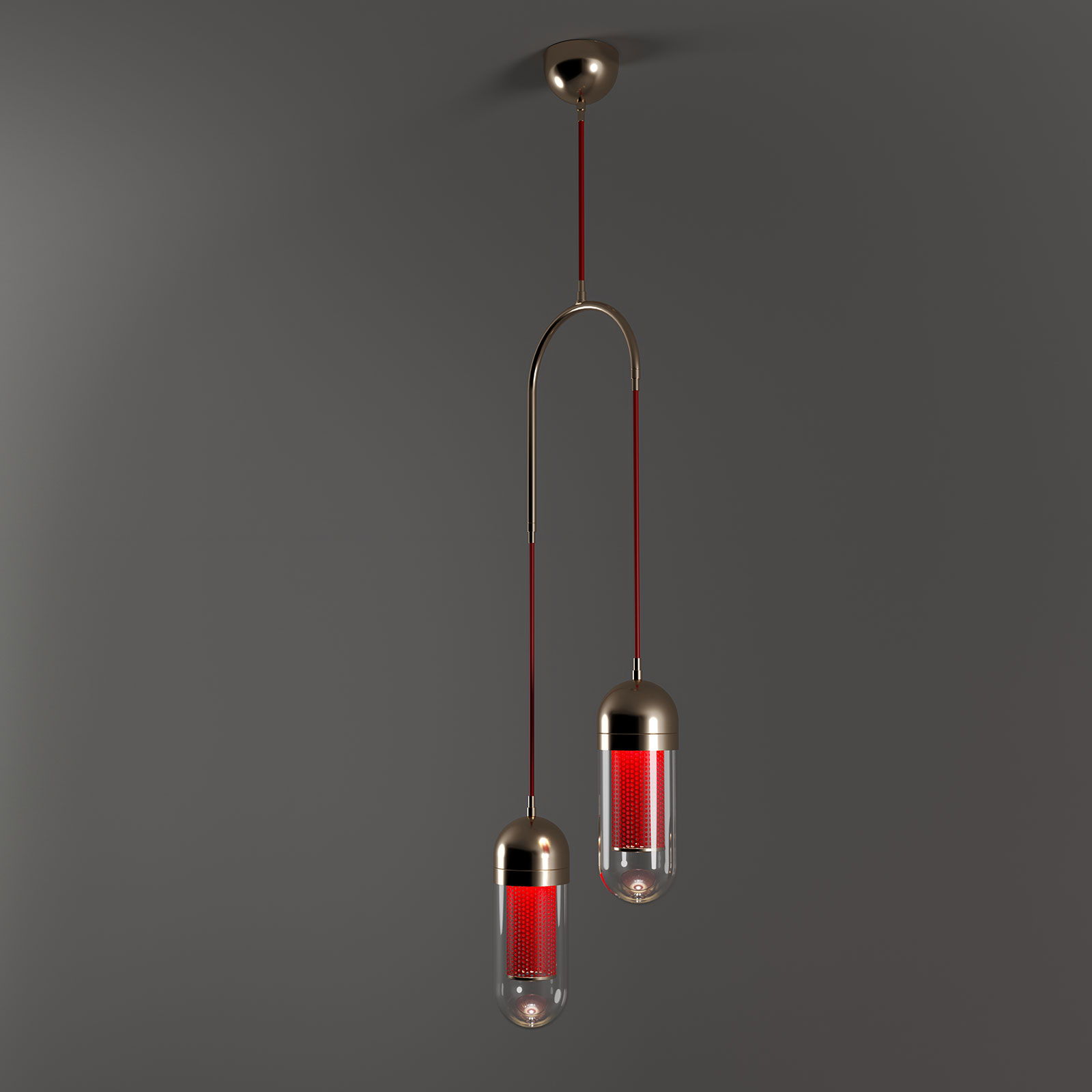 Denver II Pendant Lamp Denver II Pendant Lamp, designed by Porus Studio, features a sophisticated, asymmetric design suspended from a single ceiling mount. The structure is composed of a polished stainless steel arch that supports two vertical cables of differing lengths. Each cable terminates in a capsule-shaped light fixture featuring a metallic top, a clear glass body, and an internal core of perforated lacquered red stainless steel that creates a textured, glowing effect. The overall aesthetic combines industrial precision with a warm, luxurious contemporary finish against a dark gray background.