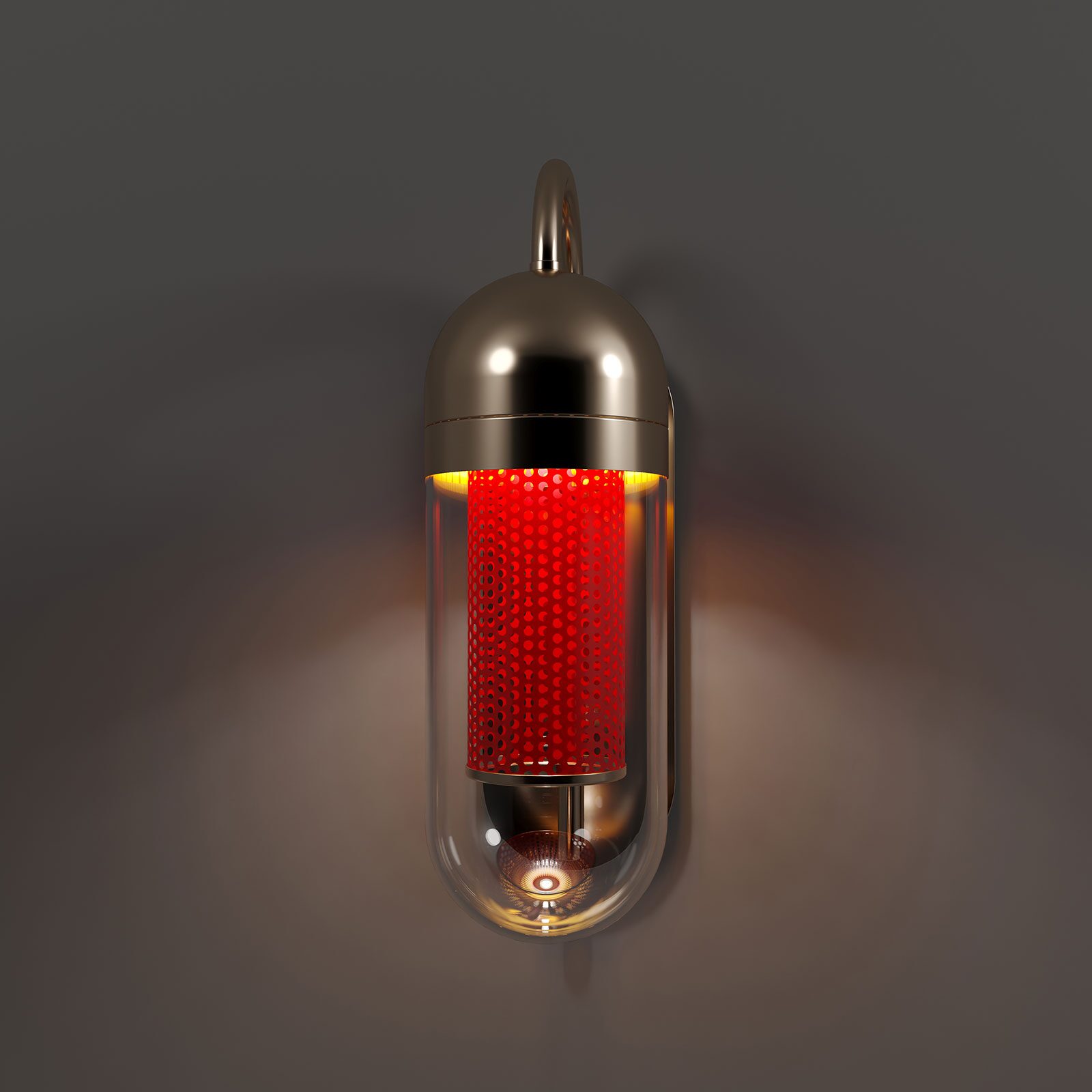 Denver Wall Lamp Front view of the Denver Wall Lamp by Porus Studio, featuring a vibrant red lacquered perforated stainless steel inner cylinder. The lamp is lit, causing the red core to glow intensely inside the clear glass pill-shaped diffuser. The mounting hardware and top dome are finished in polished brass, providing a warm contrast to the bold red center against a dark, shadowy wall.