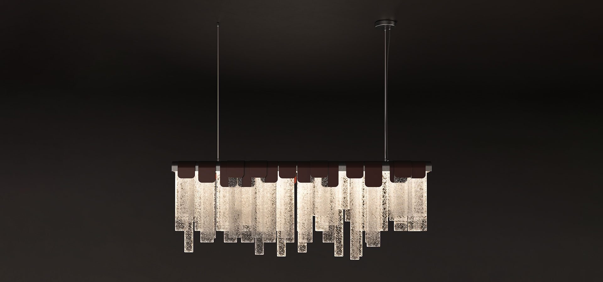 Frostlight suspension lamp illuminated against a dark background, crafted from artisanal glass and lacquered stainless steel.