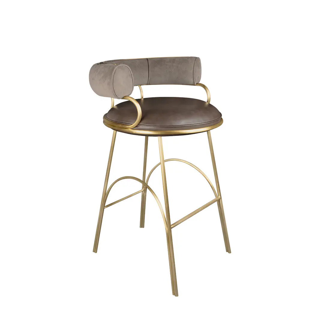 Austin bar chair shown at a 45º angle, upholstered in pescia taupe velvet pile by opuzen and hudson iron natural leather by moore & giles. The structure is made of brushed gold steel.
