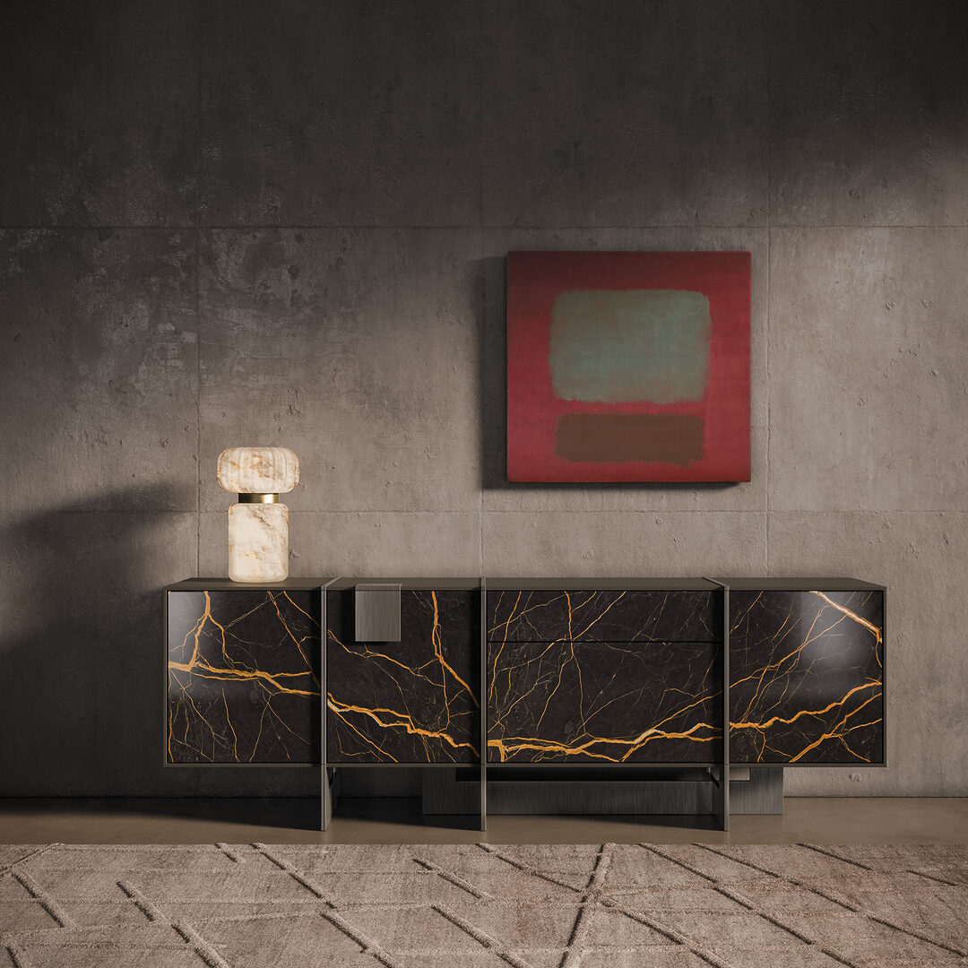 Coloma sideboard is part of our deluxe sideboards collection. Coloma sideboard with closed doors featuring brushed gun metal details and saint laurent marble, set in a dark-toned space with a hampshire table lamp iin alabaster with the light turned on.